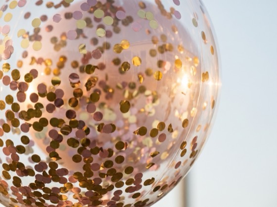 Primer plano de confeti dorado dentro de un globo burbuja transparente