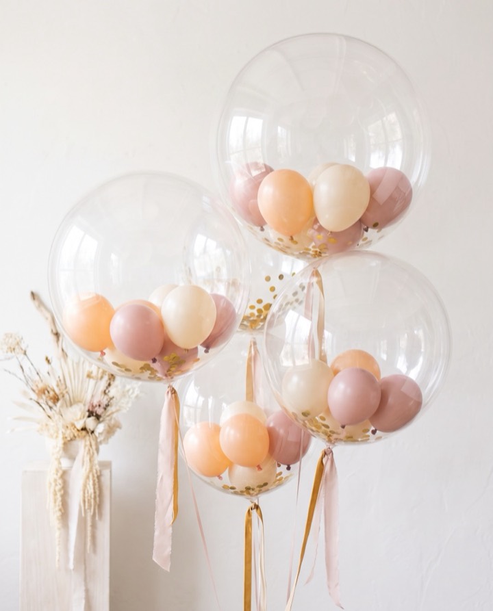 Conjunto de globos burbuja en tonos durazno y crema con globos pequeños dentro para baby shower